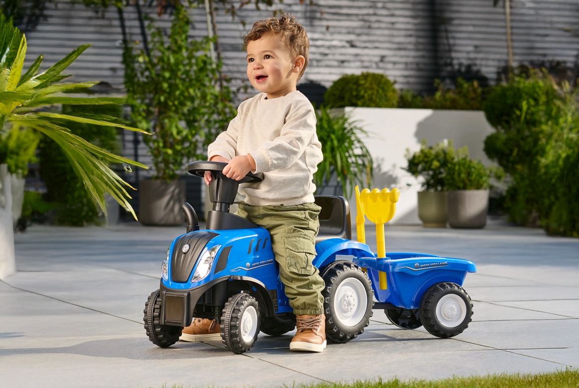 Blå New Holland gå-traktor til børn med trailer, lyd, og værktøj. Passer til børn fra 1-3 år.